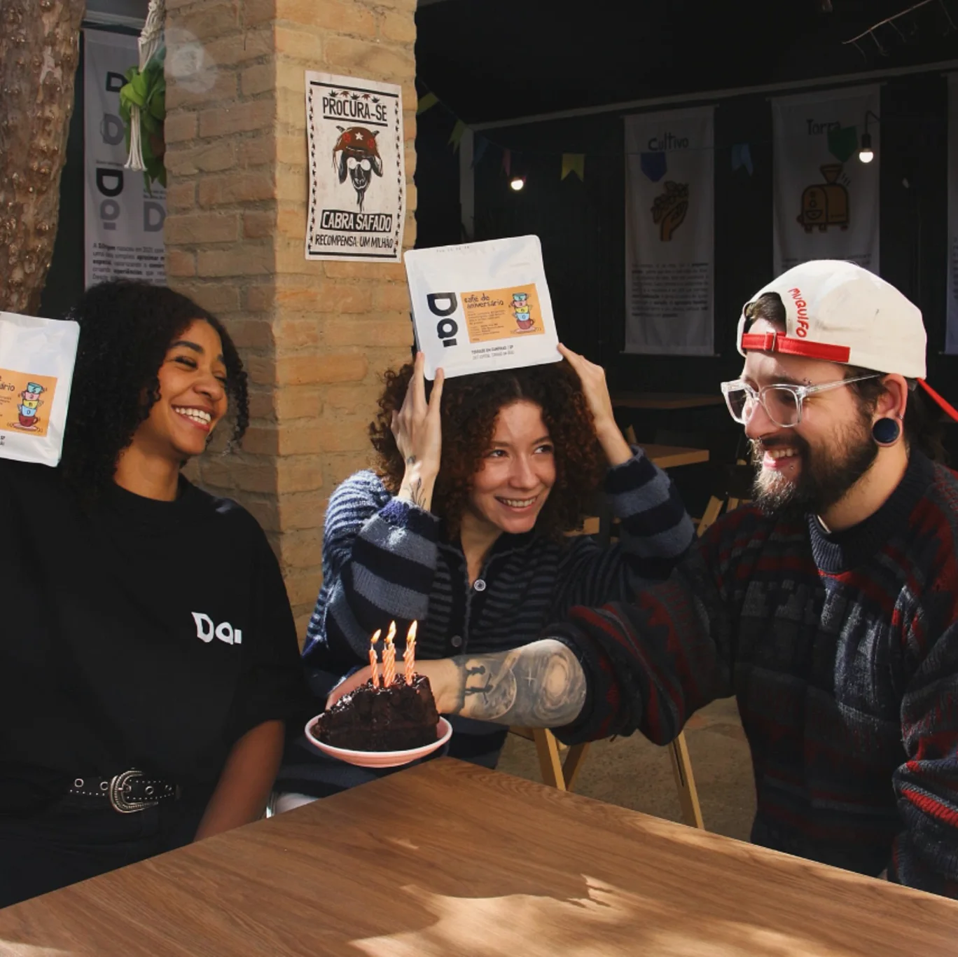 Amigos comemorando aniversário com bolo, velas e o pacote café de aniversário