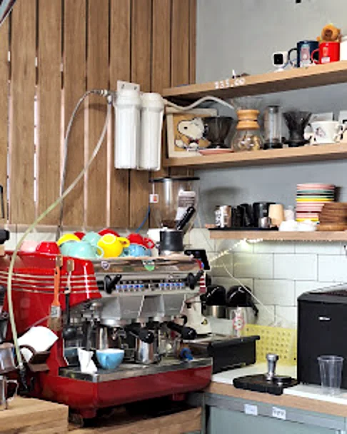 Máquina de espresso vermelha e xícaras coloridas