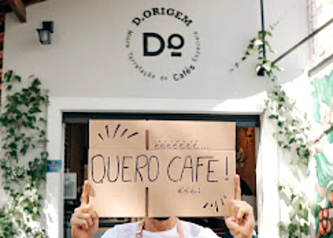 Pessoa segurando placa escrita Quero café