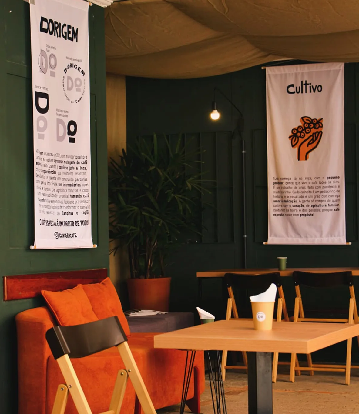 Banner Cultivo na parede verde do salão, com sofá terracota